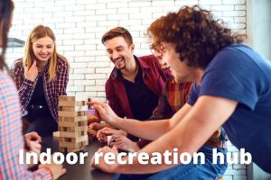 staff playing jenga, text reads 'indoor recreation hub' - clansman interiors office winter refresh - winter office refurbishment glasgow - office refurbishment scotland