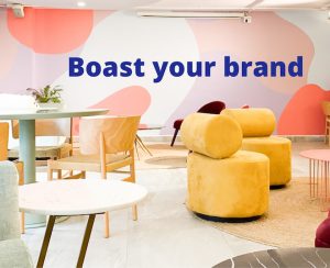 brightly coloured furniture and walls, text reads 'boast your brand' - clansman office branding wall art - clansman interiors office winter refresh